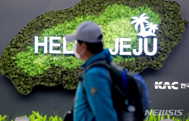 지난 28일 오후 제주공항 국내선입국장에서 마스크를 관광객이 출구로 향하고 있다.
