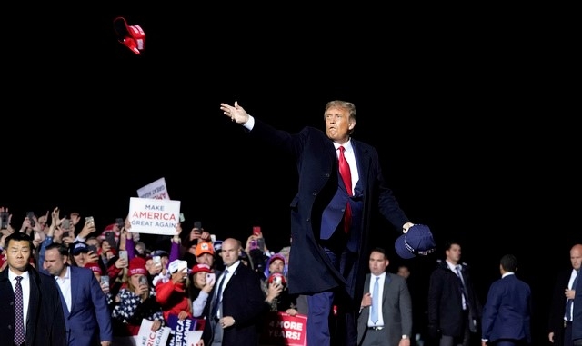 도널드 트럼프 미국 대통령이 지난달 30일 미네소타주 덜루스 국제공항에서 지지자들을 향해 유세연설을 하고서 선거용 모자를 손수 던져주고 있다. 트럼프 대통령은 그간 선거유세에 동행한 측근 호프 힉스 백악관 보좌관이 코로나19에 걸린 후 받은 검사에서 부인 멜라니아 여사와 함께 2일 양성반응을 보였다.