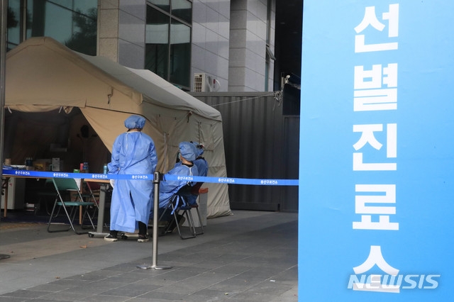 의료진이 지난달 28일 오후 서울 용산구 용산구보건소 신종 코로나바이러스 감염증(코로나19) 선별진료소에서 코로나19 검사를 받는 시민들을 기다리고 있다.