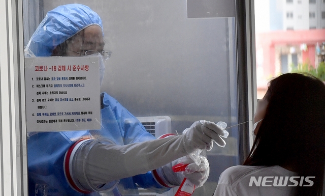 10일 오전 광주 북구보건소 코로나19 선별진료소에서 의료진이 진단 검사 대상자의 검체를 채취하고 있다.