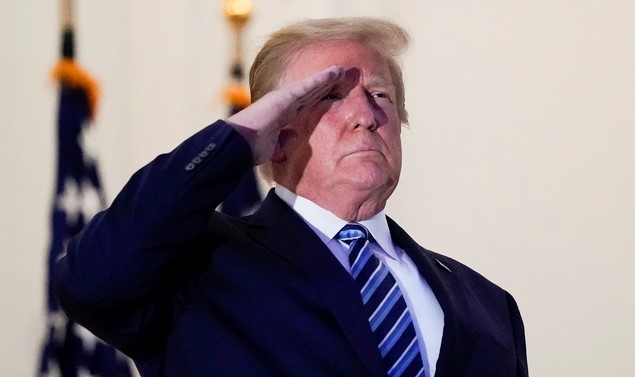 신종 코로나바이러스 감염증(코로나19)으로 입원했다가 퇴원한 도널드 트럼프 미국 대통령이 5일(현지시간) 백악관에 도착해 블루 룸 발코니에서 마스크를 벗고 경례하고 있다.