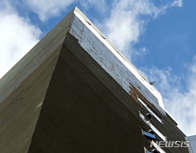 강풍주의보가 발효된 8일 오전 부산 부산진구의 한 건물 외벽 마감재가 강풍에 떨어져 나갔다. (사진=부산소방재난본부 제공)