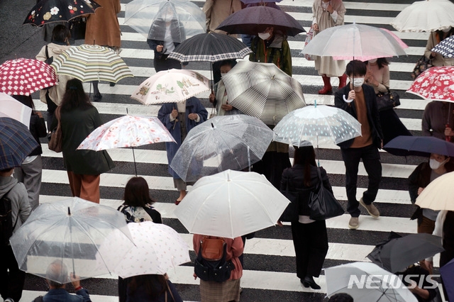 8일 일본 도쿄에 비가 내리는 가운데 우산 쓴 시민들이 건널목을 건너고 있다. 제14호 태풍 '찬홈'이 일본 열도로 접근하면서 관계 당국은 강풍과 집중 호우를 경계하고 있다.