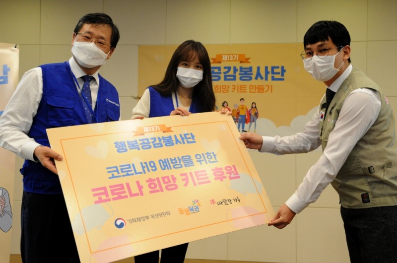 안일환 기획재정부 제2차관(왼쪽), 홍보대사 겸 행복공감봉사단장인 가수 하니(가운데)가 사단법인 따뜻한하루에 봉사단이 만든 코로나 희망키트를 전달하는 모습.