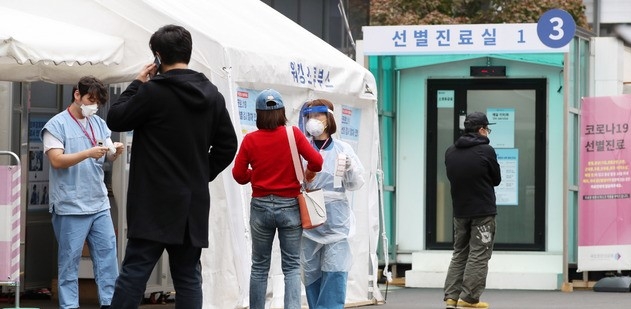 의료진이 16일 오후 서울 중구 국립중앙의료원에 마련된 선별진료소에서 내원객들에게 코로나19 검사 안내를 하고 있다.