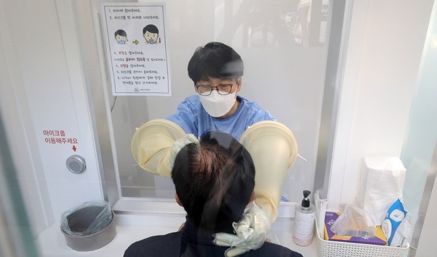 의료진이 19일 오전 서울 서초구 서초보건소에 마련된 코로나19 선별진료소에서 검체를 채취하고 있다.