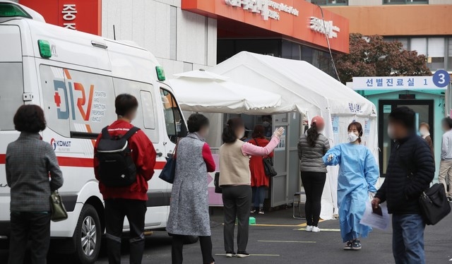  26일 오전 서울 중구 국립중앙의료원 코로나19 선별진료소에서 시민과 출국예정자들이 검사를 받기 위해 줄서 기다리고 있다. 
