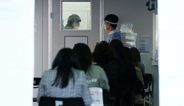서대문구 보건소 직원 2명이 신종 코로나바이러스 감염증(코로나19) 확진 판정을 받은 28일 오후 서울 서대문구 보건소 인근에 마련된 선별진료소에서 시민 등이 코로나19 검사를 받기 위해 대기하고 있다. 