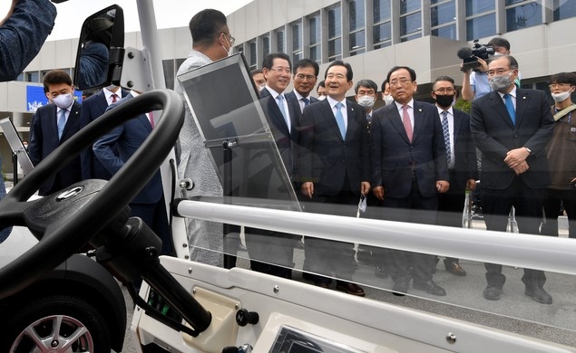 정세균 국무총리가 지난 6월17일 전남 영광군 대마전기차산업단지에서 열린 '블루 이코노미 전남, e-모빌리티 기업 투자 협약식'에 참석한 뒤 실외 시험장에 전시된 전기차 관련 설명을 듣고 있다.