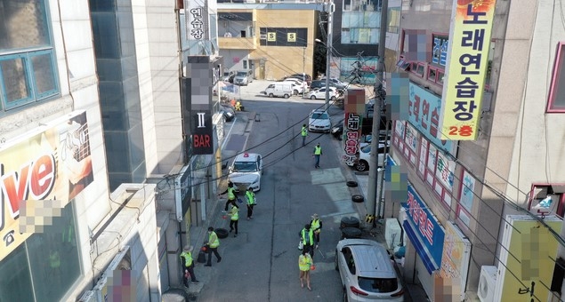 핼러윈 데이를 하루 앞둔 30일 오후 광주 북구 용봉동 유흥시설 밀집거리에서 용봉동행정복지센터 직원들과 상가협의회원들이 신종 코로나바이러스 감염증(코로나19) 예방 방역을 하고 있다.