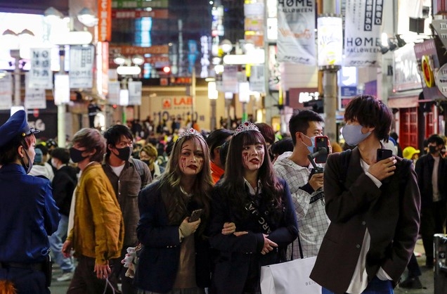 지난달 31일 일본 도쿄 시부야에서 핼로윈을 맞아 분장을 한 시민들이 길거리를 걷고 있다. 신종 코로나바이러스 감염증(코로나19) 예방을 위해 마스크를 쓴 사람과 착용하지 않고 분장한 사람이 눈에 띈다.