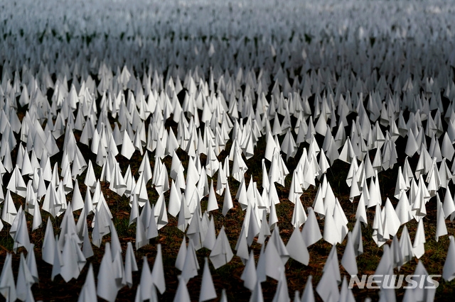 미 워싱턴 DC의 로버트 F 케네디 메모리얼 경기장 근처에 코로나19로 사망한 미국인들을 추모하는 미술 설치물로 심어진 흰 깃발에 햇빛이 비치고 있다.