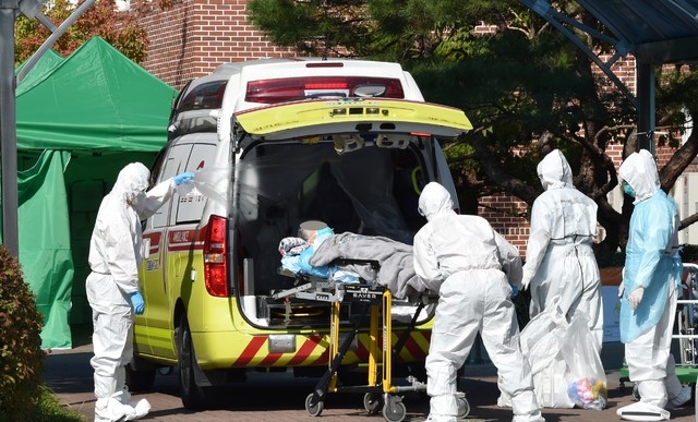 신종 코로나바이러스 감염증(코로나19)이 집단 발생한 경기 광주시 SRC 재활병원에서 지난 10월 18일 오후 관계자들이 확진자를 이송하고 있다.