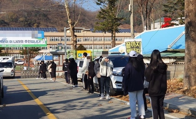 강원 인제군 북면 원통고등학교 운동장에 13일 설치된 선별진료소에서 검체채취를 하기 위해 학생들이 줄을 서서 대기하고 있다.