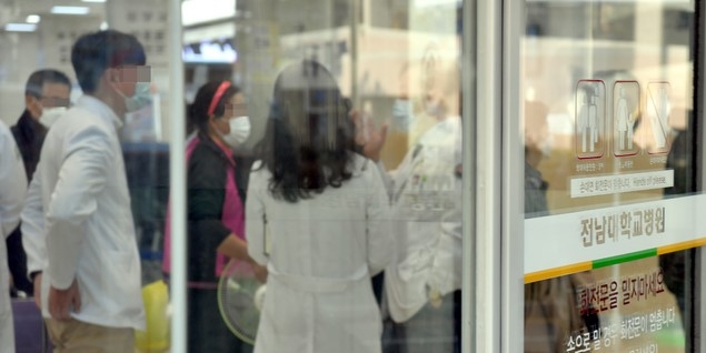 16일 오후 광주 동구 전남대학교병원 일부 병동이 신종 코로나바이러스 감염증(코로나19) 여파로 동일집단(코호트) 격리된 가운데 의료진들이 논의하고 있다.