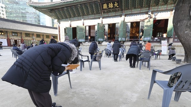 2021학년도 대학수학능력시험을 열흘 앞둔 23일 오후 사회적 거리두기로 인해 출입인원이 제한된 서울 종로구 조계사 대웅전 앞에서 불교 신자를 비롯한 학부모들이 기도를 하고 있다.
