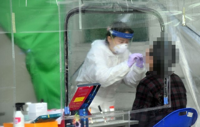부산지역에 신종 코로나바이러스 감염증(코로나19) 확진자가 잇달아 나온 24일 부산진구보건소 선별진료소를 찾은 시민들이 코로나19 진단검사를 받고 있다.