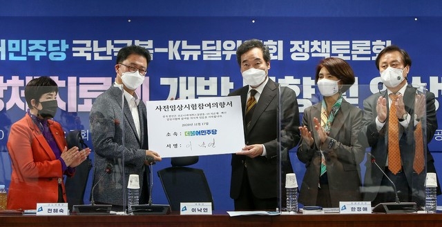 더불어민주당 이낙연(왼쪽) 대표가 지난 17일 서울 여의도 국회 의원회관에서 열린 ‘코로나19 항체치료제 개발 동향 및 임상결과 토론회’에서 사전임상시험 참여 의향서에 서명을 한 후 배병준 국가감염병임상시험지원센터 이사장에게 전달하고 있다. (공동취재사진)