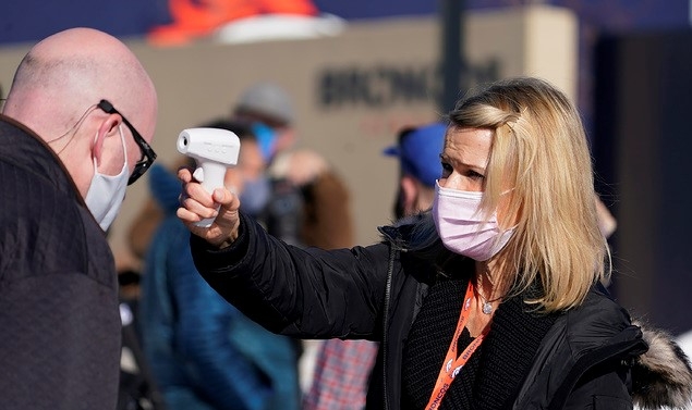 미 프로풋볼(NFL) 덴버 브롱코스의 직원 레이첼 디츠(오른쪽)가 25일(현지시간) 콜로라도주 잉글우드에서 열린 팀 훈련을 지켜보려는 한 기자의 체온을 측정하고 있다.