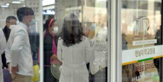 16일 오후 광주 동구 전남대학교병원 일부 병동이 신종 코로나바이러스 감염증(코로나19) 여파로 동일집단(코호트) 격리된 가운데 의료진들이 논의하고 있다. 전남대병원에서는 지난 13일부터 이날까지 의료진과 환자, 보호자 등 14명의 코로나19 확진자가 나왔다.