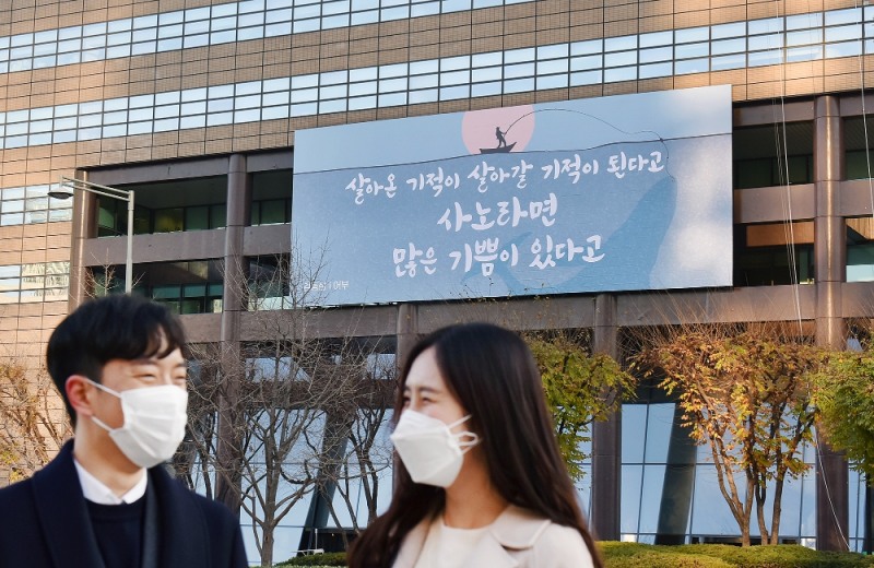 (사진=교보생명) 30일 마스크를 쓴 시민들이 교보생명 광화문글판 '겨울편'이 내걸린 광화문 교보생명빌딩 주변을 걷고 있다.