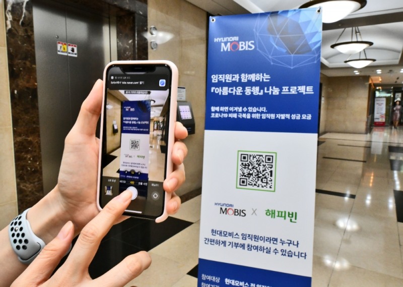 현대모비스 직원이 모바일 QR코드 방식으로 코로나19 피해 극복을 위한 자발적 기부 캠페인에 참여하고 있다.(사진제공=현대모비스)