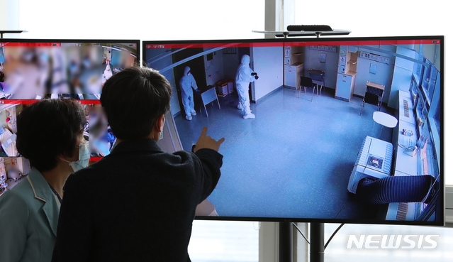 2021학년도 대학수학능력시험을 하루 앞둔 2일 서울의료원 코로나19 종합상황실에 설치된 확진 수험생을 위한 고사장 병실 CCTV 모니터에 책상 등 집기를 설치하는 의료진의 모습이 보인다. 관계자들이 이를 보며 대화하고 있다.