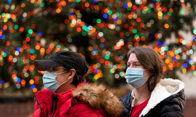  3일(현지시간) 미국 뉴욕에서 신종 코로나바이러스 감염증(코로나19)이 확산하는 가운데 마스크를 착용한 사람들이 록펠러센터 크리스마스트리를 지나가고 있다.