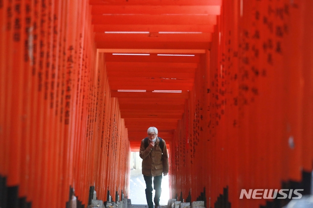 7일 일본 도쿄의 히에 신사에서 코로나19 확산 방지를 위해 마스크를 쓴 한 남성이 도리이 사이를 걷고 있다.