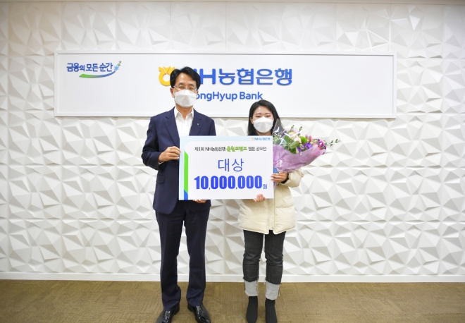 지난 7일 서울시 중구 농협은행 본점에서 진행된 올원프렌즈 웹툰 공모전 시상식을 마치고 손병환 은행장(왼쪽)과 대상을 수상한 대구가톨릭대학교 재학생팀 대표 우주연씨가 기념촬영을 하고 있다.