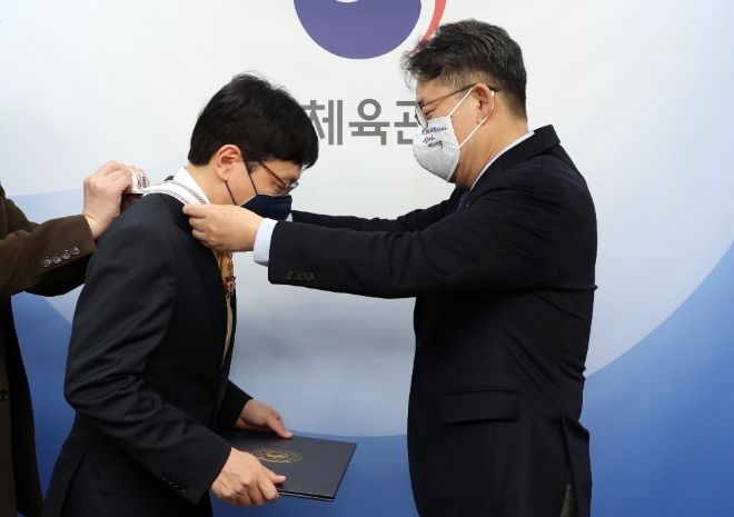 스마일게이트 창업자 권혁빈 이사장(좌측)이 8일 문화체육관광부 서울사무소에서 게임산업 최초로 보관문화훈장을 받았다. 문화관광체육부 박양우 장관(우측)이 훈장을 권 이사장 목에 걸어 주고 있다.