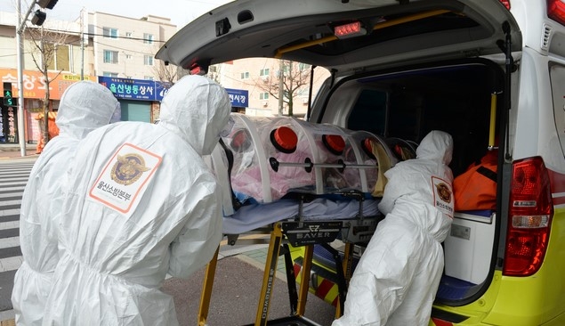 신종 코로나바이러스 감염증(코로나19) 확진자가 무더기로 발생한 울산시 남구 모 요양병원 앞에서 8일 오전 소방대원들이 확진자를 구급차로 옮기고 있다.