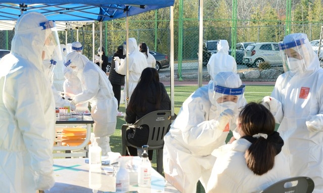 울산 남구 중학교 학생이 신종 코로나 바이러스 감염증(코로나19) 확진판정을 받은 8일 오후 해당 중학교 선별진료소에서 학생들이 코로나19 검사를 받고 있다.