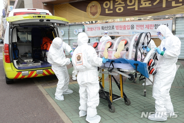 신종 코로나바이러스 감염증(코로나19) 확진자가 무더기로 발생한 울산시 남구 모 요양병원 앞에서 8일 오전 소방대원들이 확진자를 구급차로 옮기고 있다.