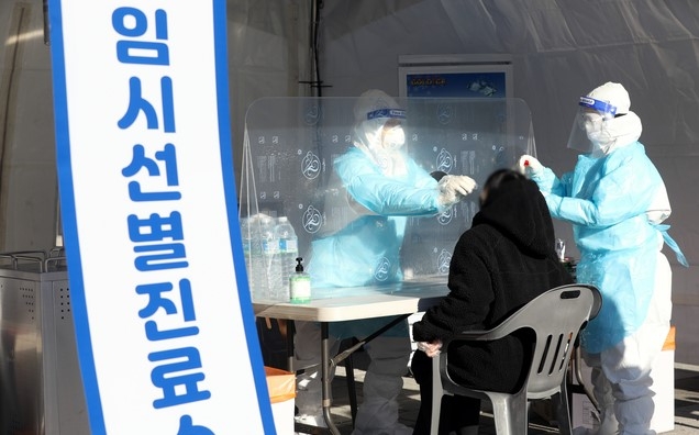 15일 서울 송파구 올림픽공원 평화의광장 방면에 설치된 신종 코로나바이러스 감염증(코로나19) 임시 선별검사소에서 의료진이 검체를 채취하고 있다.