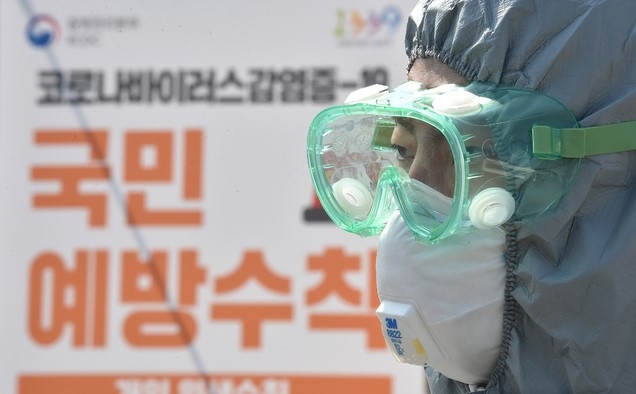 8일 오후 경기 수원시 팔달구 수원월드컵경기장에 설치된 신종 코로나바이러스 감염증(코로나19) 드라이브 스루 선별진료소에서 관계자가 검체 채취를 바라보고 있다.