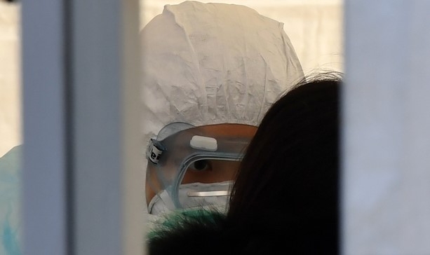 부산 부산진구 놀이마루 운동장에 마련된 신종 코로나바이러스 감염증(코로나19) 부산진구 임시선별검사소를 찾은 시민들이 21일 오전 진단검사를 받기 위해 위료진의 도움을 받아 검체를 채취하고 있다.