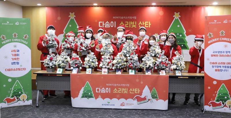 산타복을 입은 교보생명 임직원과 자원봉사자들이 크리스마스 트리를 만든 뒤 기념사진을 찍고 있다.