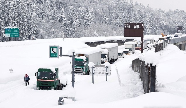 18일 일본 북부 지역에 폭설이 내린 가운데 니가타현 무이카마치 고속도로에 차량이 눈길에 묶여 있다. 현지 관계자는 이번 폭설로 수백 대의 차량이 도로에 고립되고 일부 지역에서는 정전이 발생했다고 밝혔다.