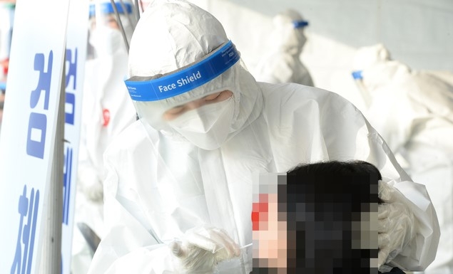 신종 코로나바이러스 감염증(코로나19)이 전국적으로 확산하고 있는 가운데 23일 오전 울산 울주군 범서생활체육공원에 마련된 선별진료소에서 의료진이 검체 채취를 하고 있다.