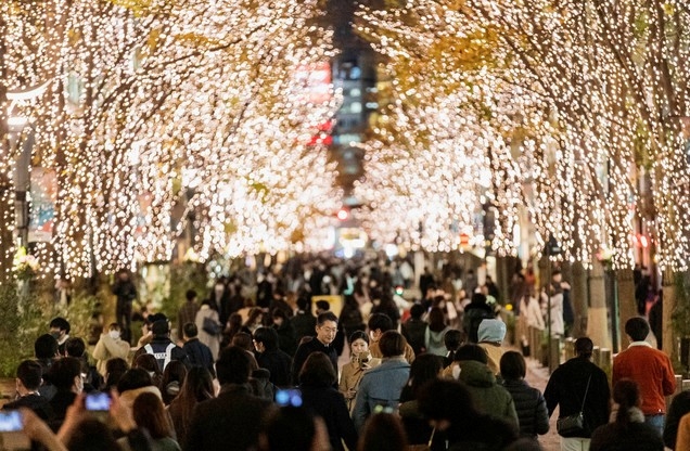 크리스마스 전날인 24일 일본 도쿄의 한 거리에서 시민들이 나무에 장식된 조명을 휴대폰으로 촬영하고 있다. 이날 일본의 신종 코로나바이러스 감염증(코로나19) 신규 확진자 수는 최다를 기록했다.