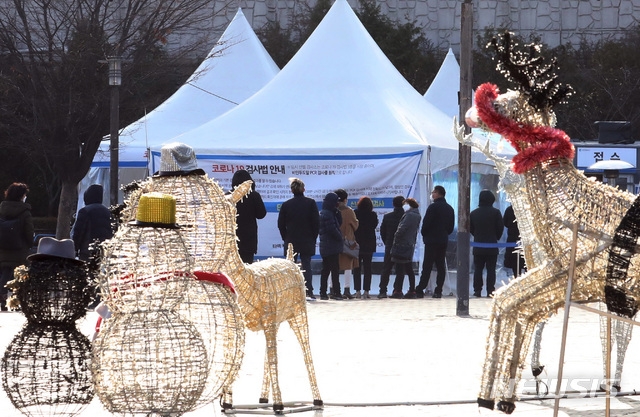 크리스마스를 하루 앞둔 24일 오후 인천시 중구 동인천역북광장 루돌프 사슴 조형물 앞에 설치된 신종 코로나바이러스 감염증(코로나19) 임시선별검사소에서 시민들이 검사를 받고 있다.