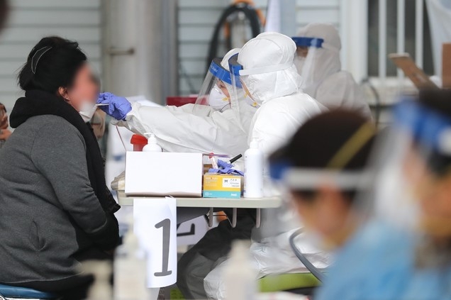 제주 도내 신종 코로나바이러스 감염증(코로나19) 확진자가 속출한 18일 오후 제주시보건소에 마련된 선별진료소에서 의료진들이 구슬땀을 흘리며 검체 채취에 집중하고 있다.