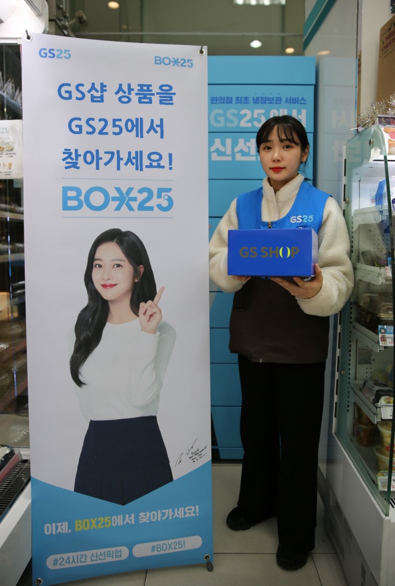 (사진=GS리테일) GS25 BOX25 앞에서 모델이 GS샵 박스를 들고 홍보물 옆에서 포즈를 취하고 있다.
