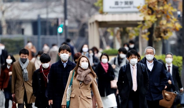 28일(현지시간) 신종 코로나바이러스 감염증(코로나19)이 확산중인 일본 도쿄에서 마스크를 쓴 시민들이 한 역에서 걸어 나오고 있다.