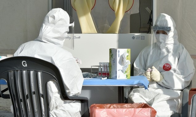 신종 코로나바이러스 감염증(코로나19) 신규 확진자 수가 사흘 만에 1000명대로 늘어난 29일 오전 대구 달서구 두류공원에 마련된 임시 선별진료소에서 의료진이 핫팩으로 몸을 녹이고 있다.