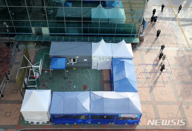 2020년 마지막 날인 31일 오후 서울 성동구 성동구청 농구장에 마련된 신종 코로나 바이러스 감염증(코로나19) 임시선별검사소에서 시민들이 검사를 받기 위해 줄 지어 서 있다.