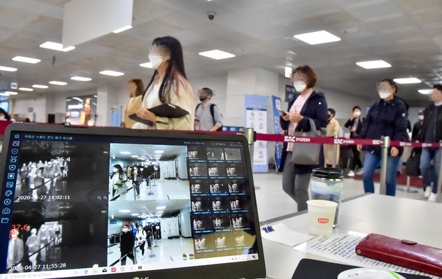 정부가 사회적 거리두기를 제한적으로 완화한 가운데 27일 오후 제주공항 국내선입국장에 관광객들이 신종 코로나바이러스 감염증(코로나19) 확산 방지를 위한 발열 검사대를 통과하고 있다.