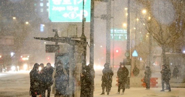 연일 한파가 이어지며 눈이 내리고 있는 지난 6일 오후 서울 종로구 광화문네거리에서 시민들이 버스를 기다리고 있다.