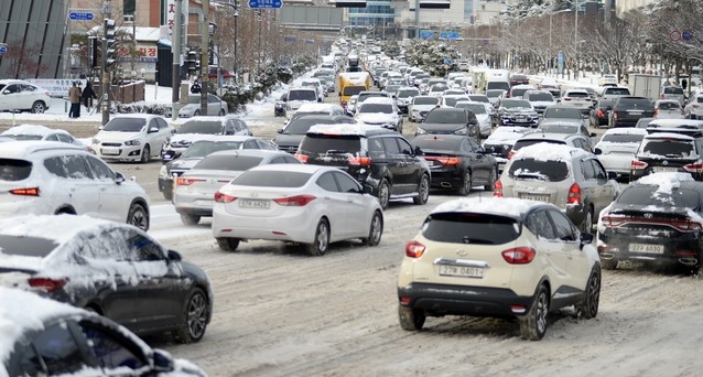 전북지역에 폭설이 내린 7일 전북 전주시 덕진구 백제대로에서 출근하는 운전자들이 눈 가득 쌓인 혼잡한 도로를 천천히 달리고 있다.